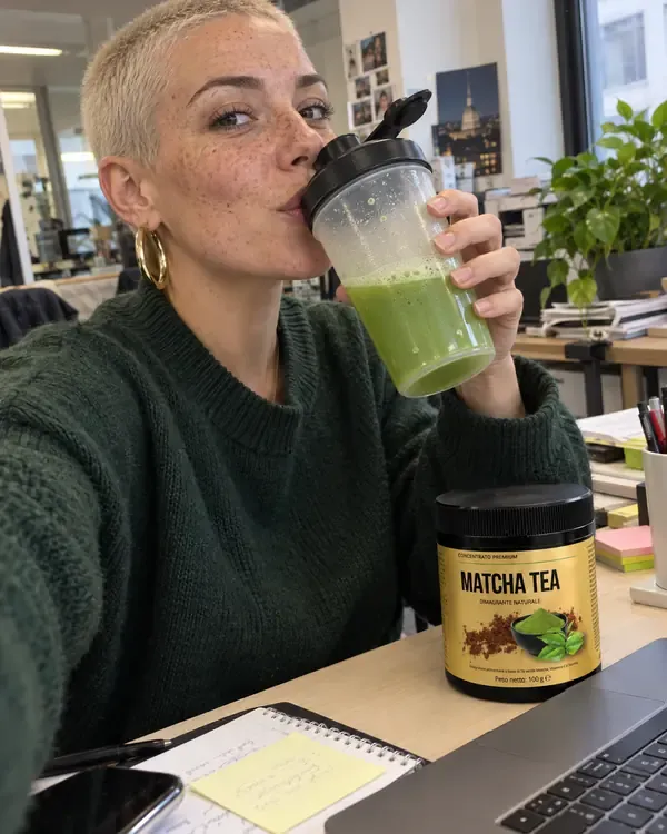 Sara alla scrivania dell'ufficio che beve il matcha dallo shaker