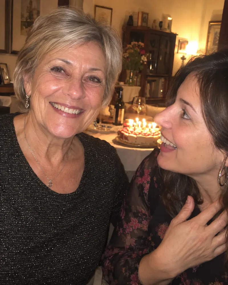 Daniela, 61 anni, sorridente alla festa di compleanno con la figlia accanto