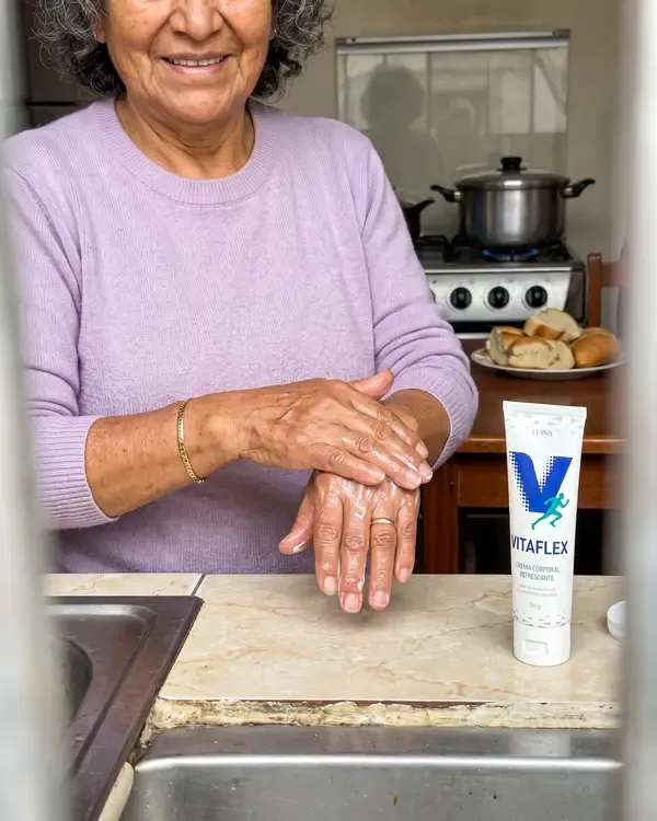 Carmen aplicándose Vitaflex en las manos en la cocina